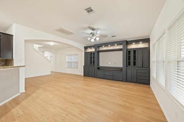 2827 Arica Ln, Spring, TX 77373 - unfurnished living room with a ceiling fan, arched walkways, and light wood finished floors