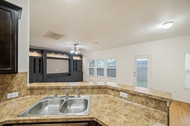 2827 Arica Ln, Spring, TX 77373 - kitchen with a sink, a ceiling fan, wood finished floors, light countertops, and decorative backsplash