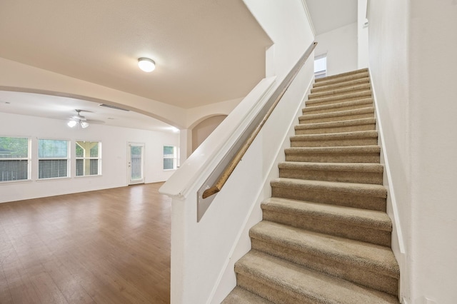 2827 Arica Ln, Spring, TX 77373 - stairs featuring a ceiling fan, arched walkways, and wood finished floors