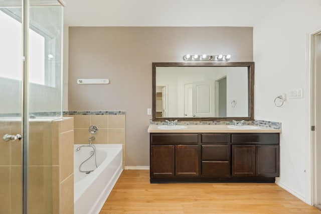 2827 Arica Ln, Spring, TX 77373 - full bathroom featuring a garden tub, wood finished floors, double vanity, and a shower with door