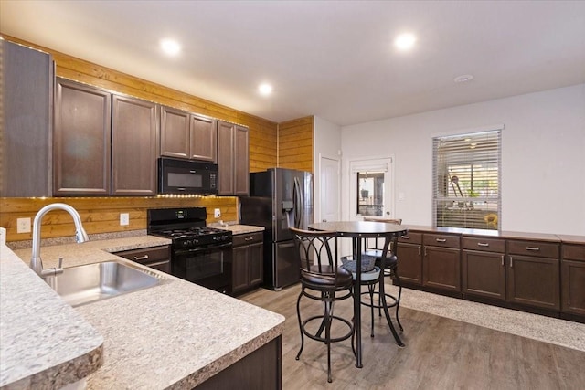 1685 Rd 5102, Cleveland, TX 77327 - kitchen with black appliances, a sink, light wood-type flooring, light countertops, and dark brown cabinets