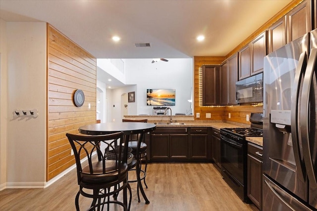 1685 Rd 5102, Cleveland, TX 77327 - kitchen featuring black appliances, a sink, light wood-style flooring, wooden walls, and baseboards