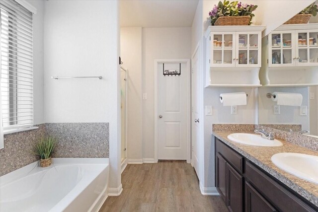 1685 Rd 5102, Cleveland, TX 77327 - bathroom featuring wood finished floors, a bath, plenty of natural light, and double vanity