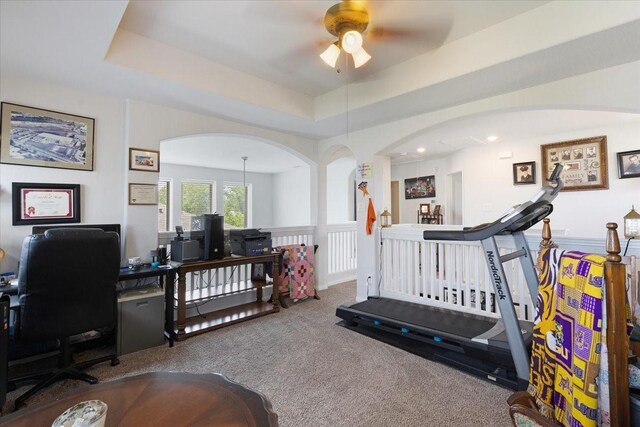 1685 Rd 5102, Cleveland, TX 77327 - workout room featuring a ceiling fan, carpet, arched walkways, and a tray ceiling