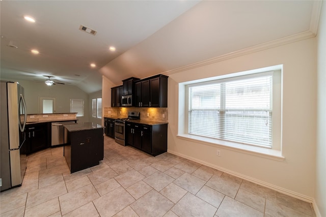 18423 Weeping Spring Dr, Cypress, TX 77429 - kitchen with appliances with stainless steel finishes, tasteful backsplash, a kitchen island, lofted ceiling, and a ceiling fan