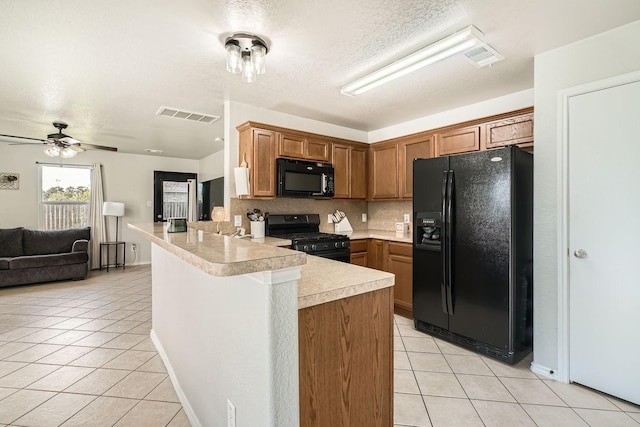 503 Savory Ln, Crosby, TX 77532 - kitchen with black appliances, a peninsula, light tile patterned floors, light countertops, and open floor plan