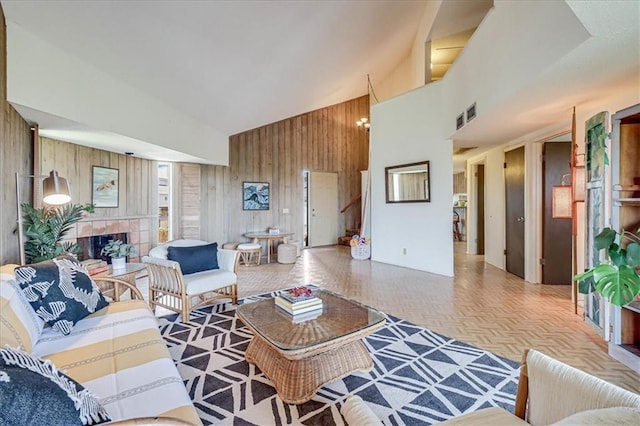 635 Lantana Dr, Port Aransas, TX 78373 - living area featuring wood walls, high vaulted ceiling, and a tiled fireplace