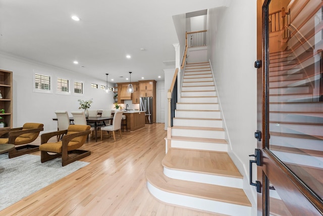 26 Riva Row, The Woodlands, TX 77380 - staircase with wood finished floors, recessed lighting, and crown molding