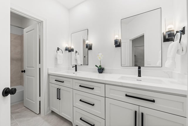 26 Riva Row, The Woodlands, TX 77380 - bathroom featuring double vanity, marble look tiles, and tub / shower combination