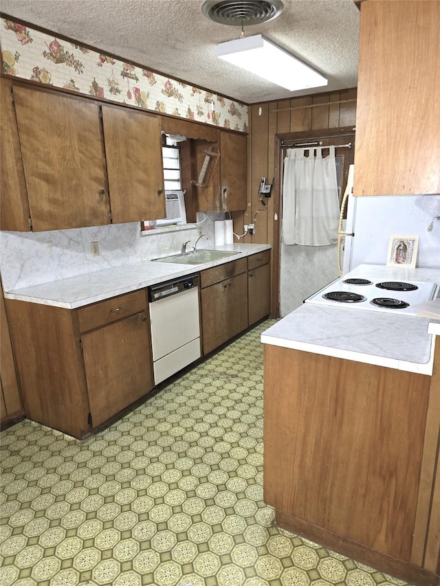1205 Appling St, El Campo, TX 77437 - kitchen featuring white dishwasher, light countertops, light floors, a textured ceiling, and a sink