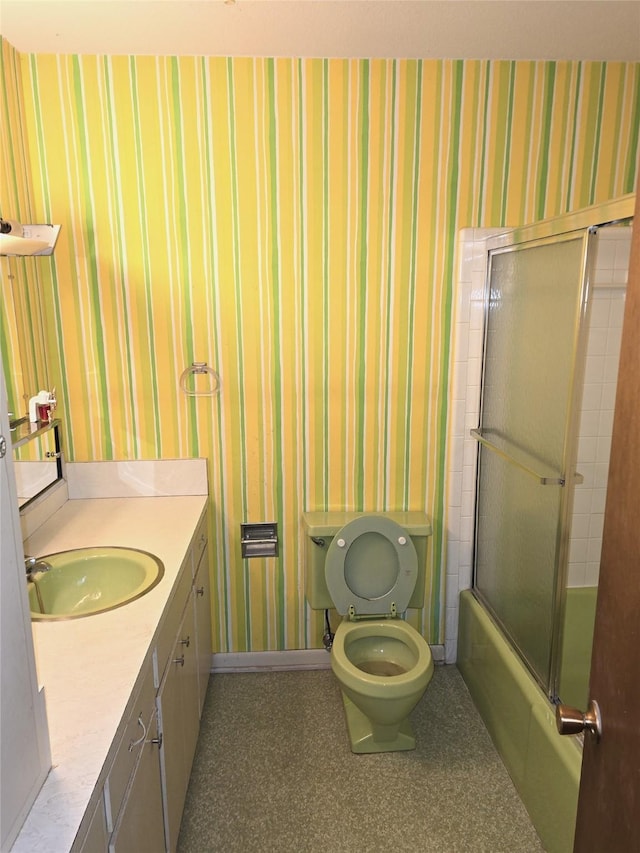 1205 Appling St, El Campo, TX 77437 - full bath with wallpapered walls, vanity, toilet, bath / shower combo with glass door, and baseboards