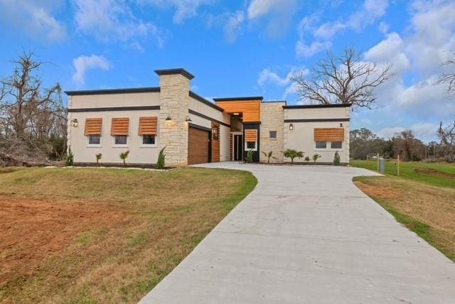 209 Horse Shoe Trl, Angleton, TX 77515 - modern home featuring driveway, an attached garage, a front lawn, stone siding, and stucco siding