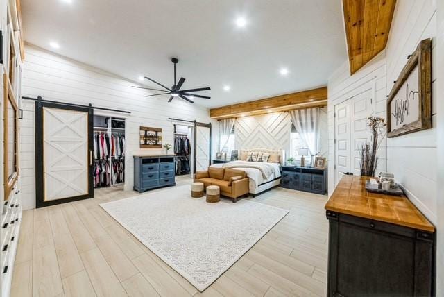 209 Horse Shoe Trl, Angleton, TX 77515 - bedroom featuring a barn door, light wood finished floors, and recessed lighting