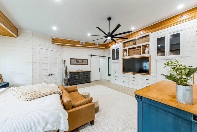 209 Horse Shoe Trl, Angleton, TX 77515 - bedroom with a barn door, recessed lighting, wood finished floors, and a closet