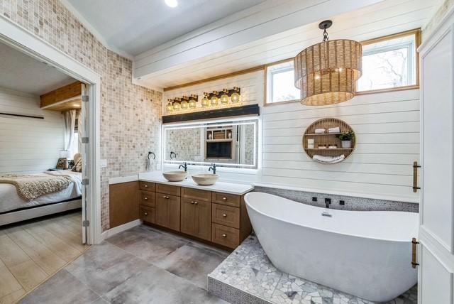 209 Horse Shoe Trl, Angleton, TX 77515 - ensuite bathroom featuring vanity, a freestanding tub, and wood walls