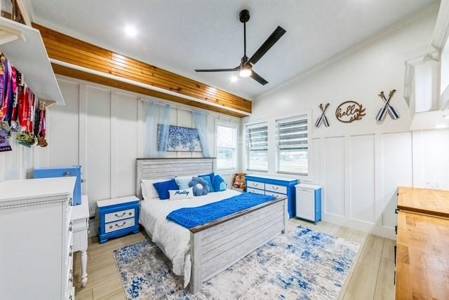 209 Horse Shoe Trl, Angleton, TX 77515 - bedroom with a decorative wall, light wood-style floors, and ceiling fan