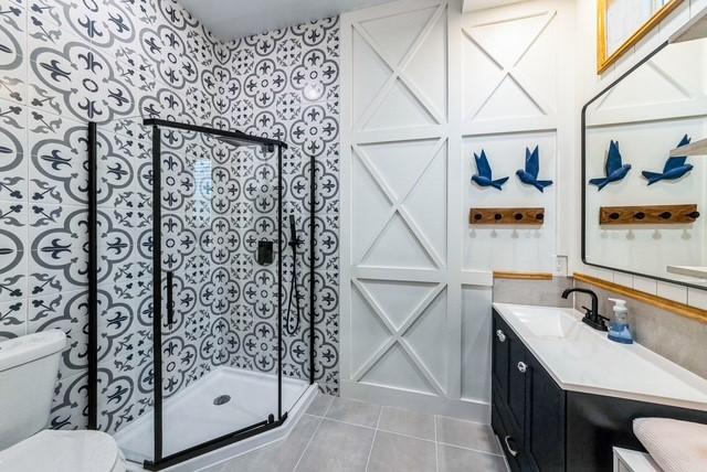 209 Horse Shoe Trl, Angleton, TX 77515 - bathroom featuring a stall shower, tile patterned flooring, toilet, and vanity