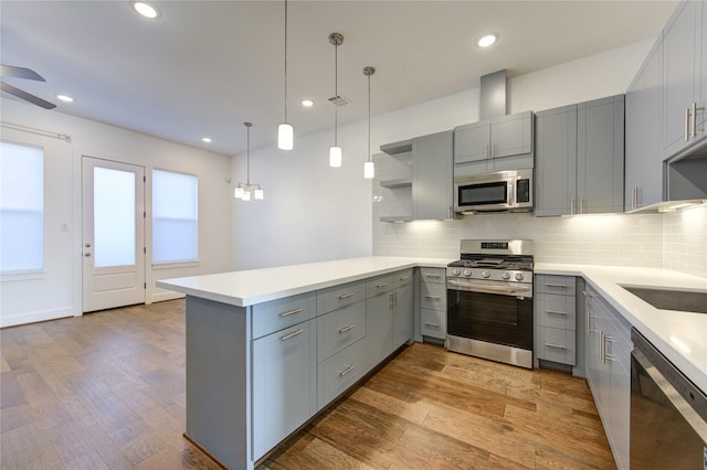 8964 Zurcher Ln, Houston, TX 77080 - kitchen featuring appliances with stainless steel finishes, gray cabinetry, a peninsula, open shelves, and recessed lighting