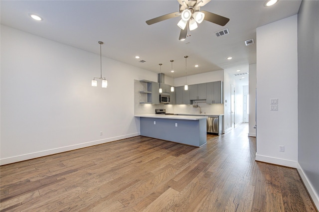8964 Zurcher Ln, Houston, TX 77080 - kitchen with appliances with stainless steel finishes, a peninsula, gray cabinets, light countertops, and ceiling fan