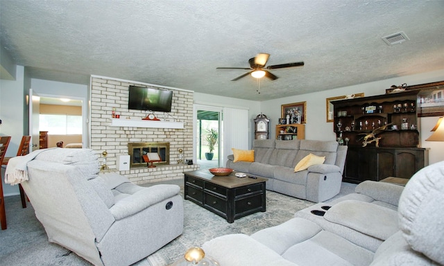 12662 Hackberry Dr, Willis, TX 77318 - living area with a ceiling fan, a fireplace, carpet, and a textured ceiling