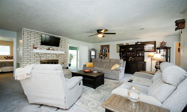 12662 Hackberry Dr, Willis, TX 77318 - living room with ceiling fan, a textured ceiling, a brick fireplace, and carpet floors
