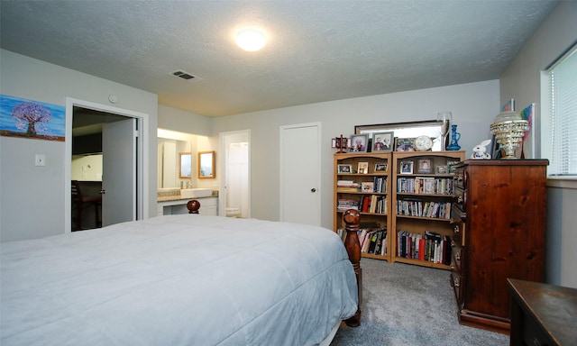 12662 Hackberry Dr, Willis, TX 77318 - carpeted bedroom featuring a textured ceiling and connected bathroom