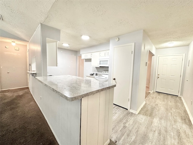 4515 Mossygate Dr, Spring, TX 77373 - kitchen featuring white appliances, a textured ceiling, a peninsula, baseboards, and light countertops