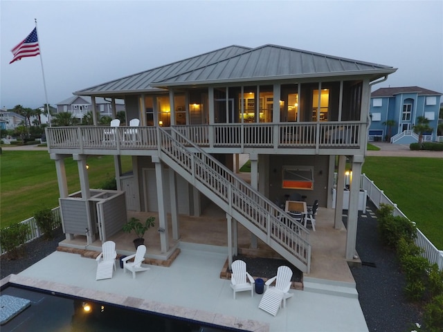 13830 Windlass Cir, Galveston, TX 77554 - back of house with a standing seam roof, a patio, stairway, and a yard