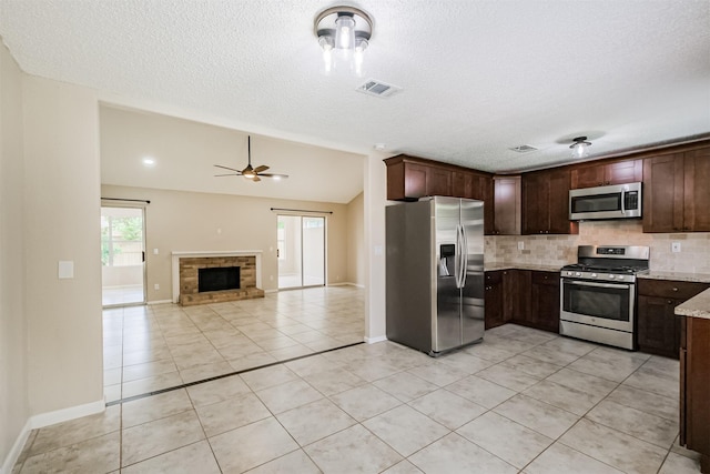 2738 Kettle Run, Sugar Land, TX 77479 - kitchen featuring stainless steel appliances, backsplash, light tile patterned floors, ceiling fan, and vaulted ceiling