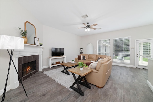 1706 Maddie Springs Ct, Spring, TX 77386 - living room featuring wood finished floors, a tiled fireplace, a ceiling fan, and baseboards