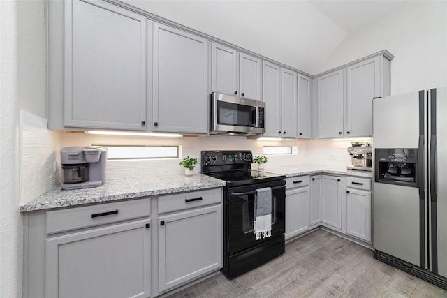 1706 Maddie Springs Ct, Spring, TX 77386 - kitchen featuring appliances with stainless steel finishes, lofted ceiling, light wood-style floors, backsplash, and light stone counters