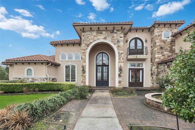 4510 Siandra Creek Ct, Spring, TX 77386 - view of front of house featuring french doors, stone siding, stucco siding, a balcony, and a tiled roof