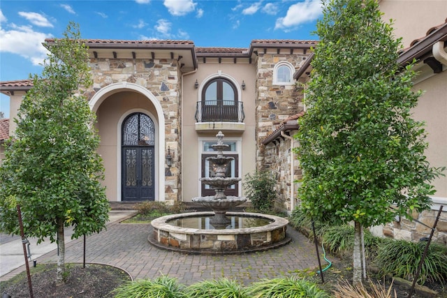 4510 Siandra Creek Ct, Spring, TX 77386 - view of front of house featuring french doors, stone siding, stucco siding, a balcony, and a tile roof
