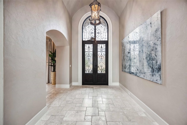 4510 Siandra Creek Ct, Spring, TX 77386 - foyer with arched walkways, stone tile flooring, french doors, baseboards, and lofted ceiling