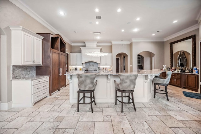 4510 Siandra Creek Ct, Spring, TX 77386 - kitchen with decorative backsplash, crown molding, stone tile floors, white cabinets, and light stone counters