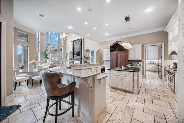 4510 Siandra Creek Ct, Spring, TX 77386 - kitchen featuring a spacious island, stone tile flooring, double oven range, crown molding, and recessed lighting