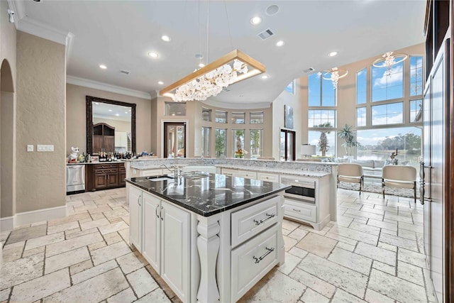 4510 Siandra Creek Ct, Spring, TX 77386 - kitchen featuring stone tile floors, a spacious island, a sink, crown molding, and recessed lighting