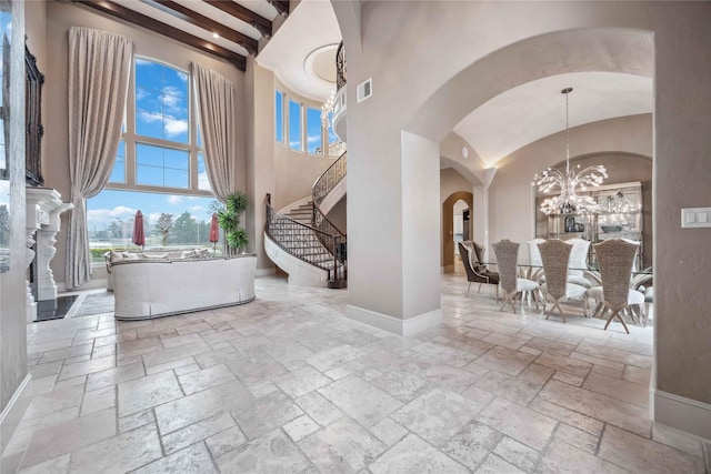 4510 Siandra Creek Ct, Spring, TX 77386 - entryway with stone tile flooring, a chandelier, arched walkways, a high ceiling, and baseboards