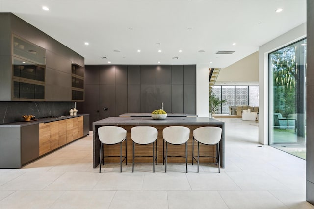 11206 Tyne Ct, Houston, TX 77024 - kitchen featuring modern cabinets, a breakfast bar, dark countertops, and recessed lighting