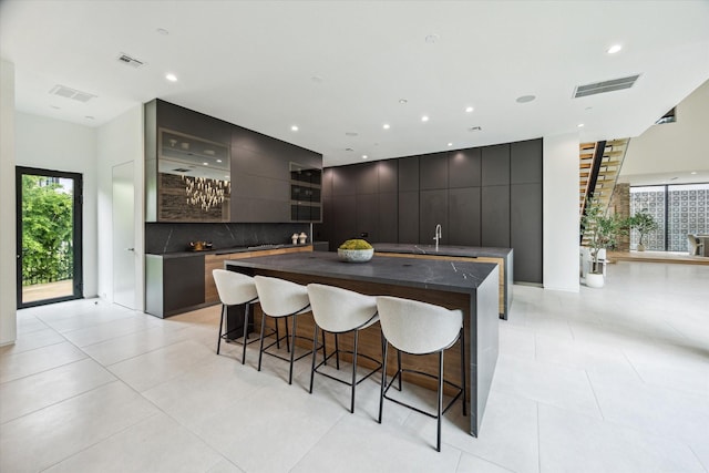 11206 Tyne Ct, Houston, TX 77024 - kitchen with modern cabinets, dark countertops, a large island, a kitchen breakfast bar, and recessed lighting