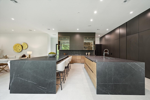 11206 Tyne Ct, Houston, TX 77024 - kitchen with modern cabinets, a large island, a sink, recessed lighting, and tasteful backsplash