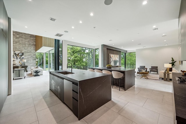 11206 Tyne Ct, Houston, TX 77024 - kitchen featuring a large island with sink, modern cabinets, open floor plan, dark countertops, and recessed lighting