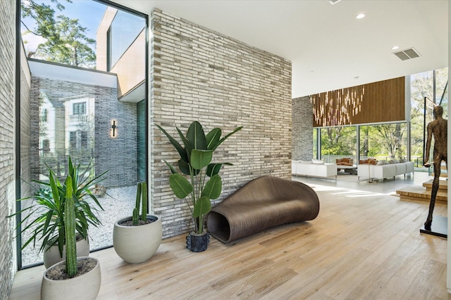 11206 Tyne Ct, Houston, TX 77024 - living area with a towering ceiling, wood finished floors, brick wall, and plenty of natural light