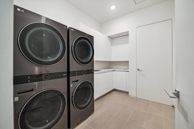 11206 Tyne Ct, Houston, TX 77024 - laundry room featuring stacked washer / dryer, light tile patterned flooring, cabinet space, and separate washer and dryer