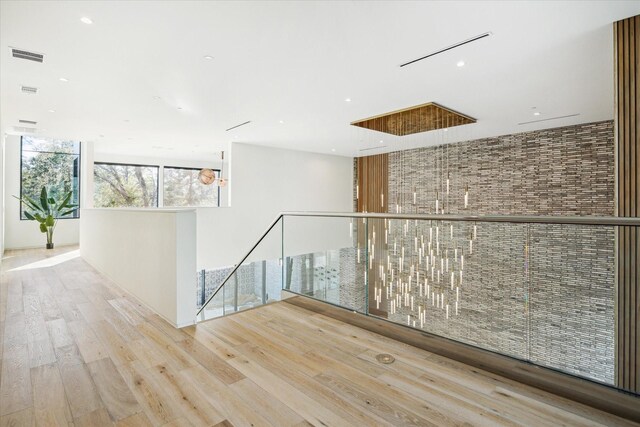 11206 Tyne Ct, Houston, TX 77024 - hall with an upstairs landing, wood finished floors, and recessed lighting