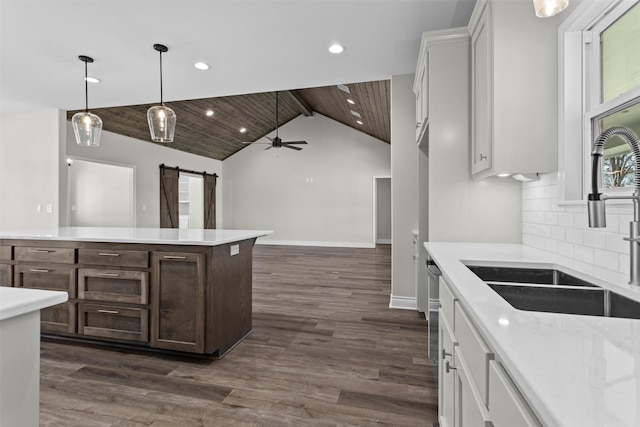 595 Fm 2968, Grapeland, TX 75844 - kitchen featuring a barn door, a sink, tasteful backsplash, lofted ceiling, and dark wood-type flooring