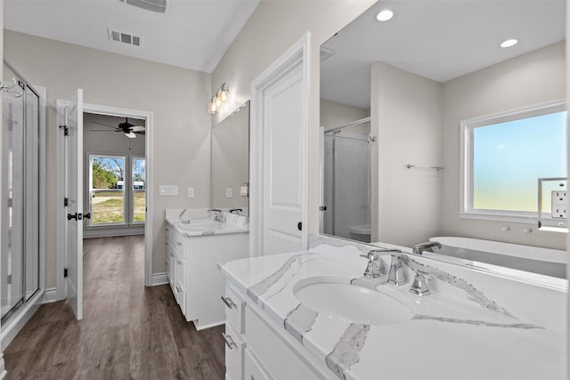 595 Fm 2968, Grapeland, TX 75844 - bathroom with a shower stall, two vanities, wood finished floors, a ceiling fan, and recessed lighting
