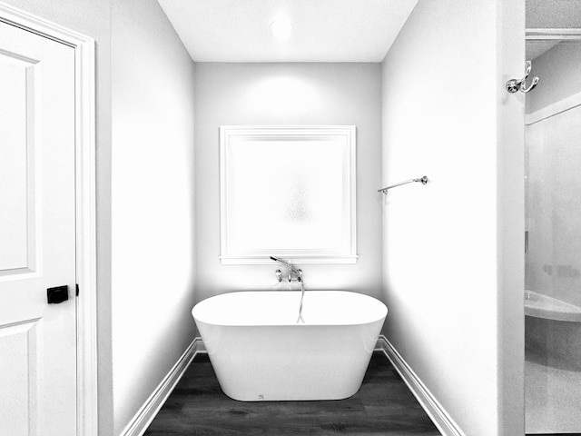 595 Fm 2968, Grapeland, TX 75844 - bathroom featuring wood finished floors, a soaking tub, and baseboards