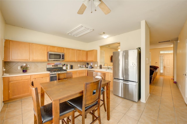 23610 Youpon Lake Ln, Spring, TX 77373 - kitchen featuring stainless steel appliances, light brown cabinets, a sink, and light tile patterned floors