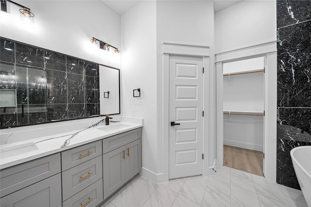 4902 Higgins St B, Unit A, Houston, TX 77033 - full bath featuring marble look tile flooring, a soaking tub, a walk in closet, double vanity, and baseboards